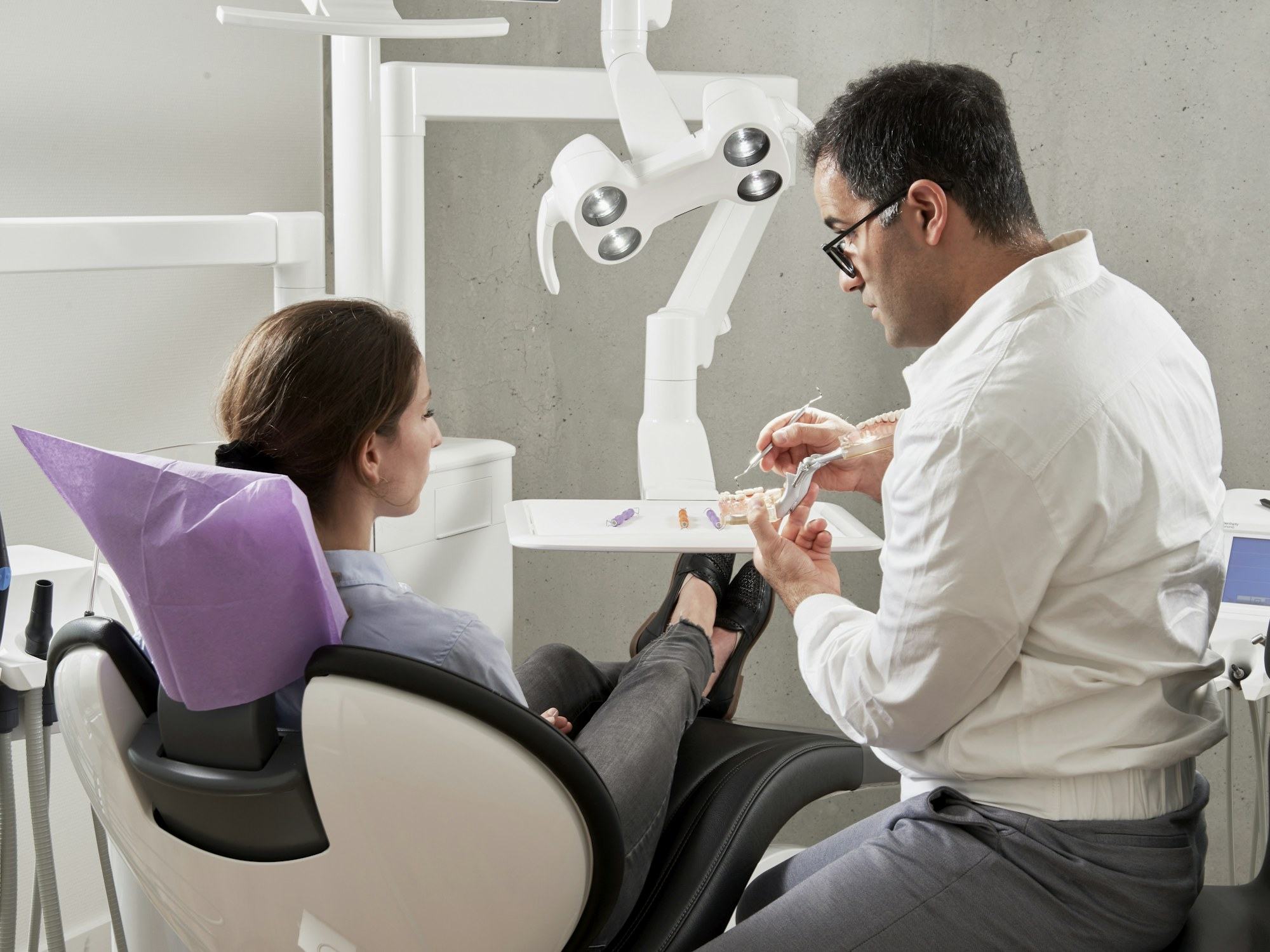 A dentist showing a patient a model of the teeth