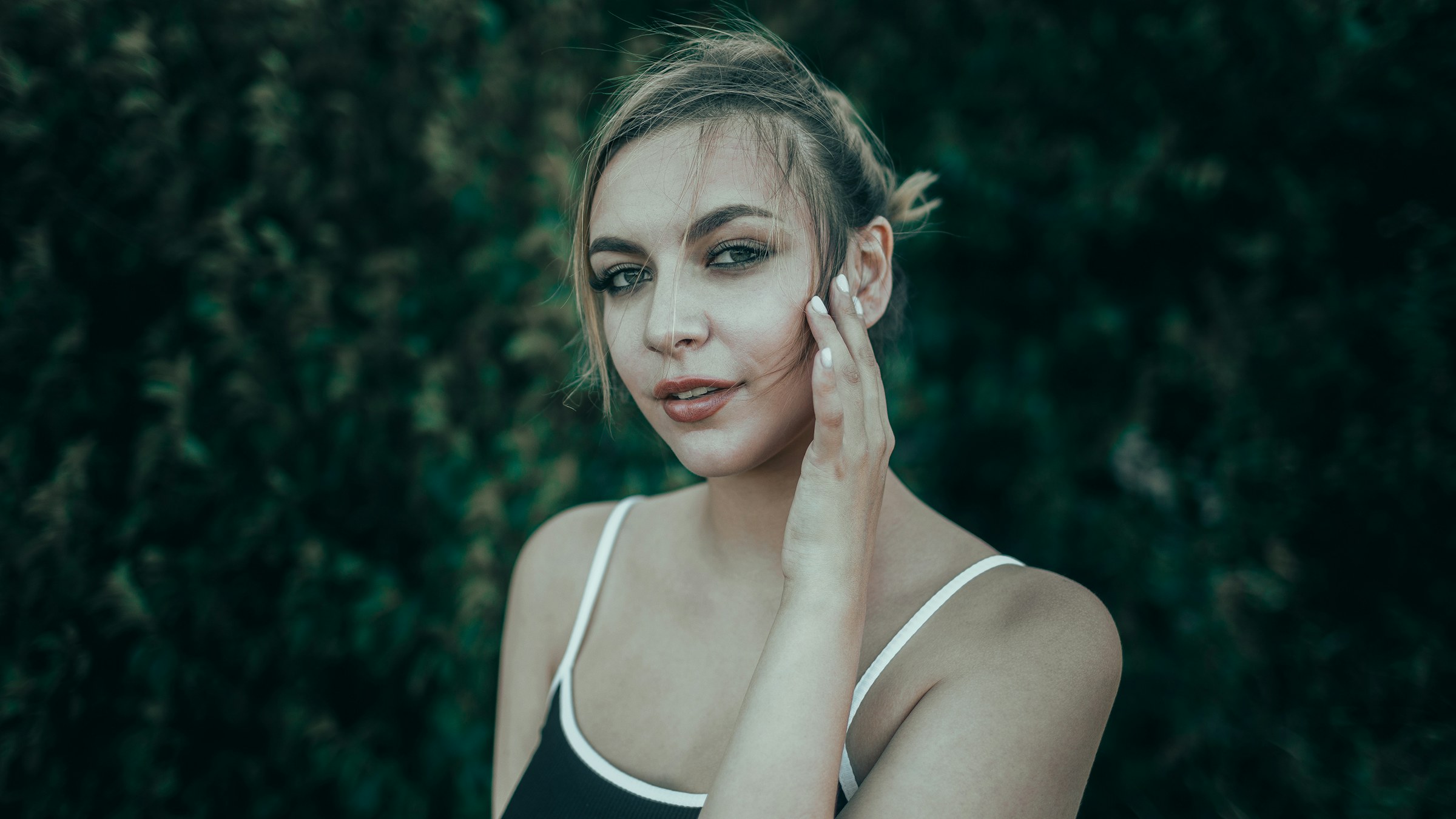 A young woman with her hand to her cheek